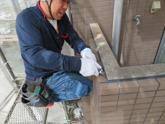 ベランダ外壁上端のコーキングを撤去する
