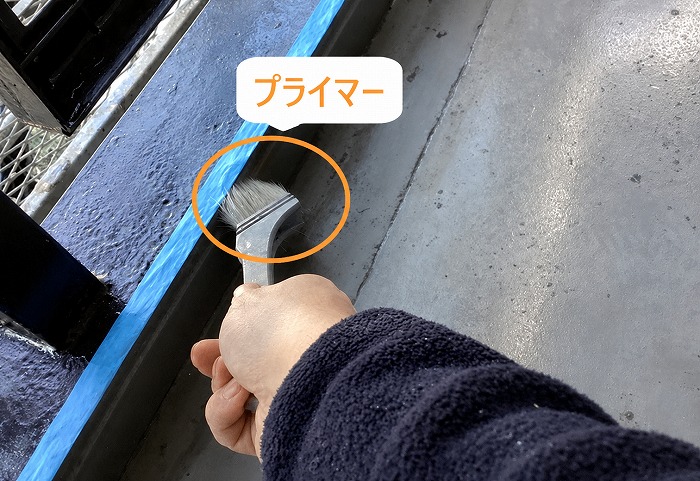 集合住宅のベランダ防水工事でプライマーを塗っている様子