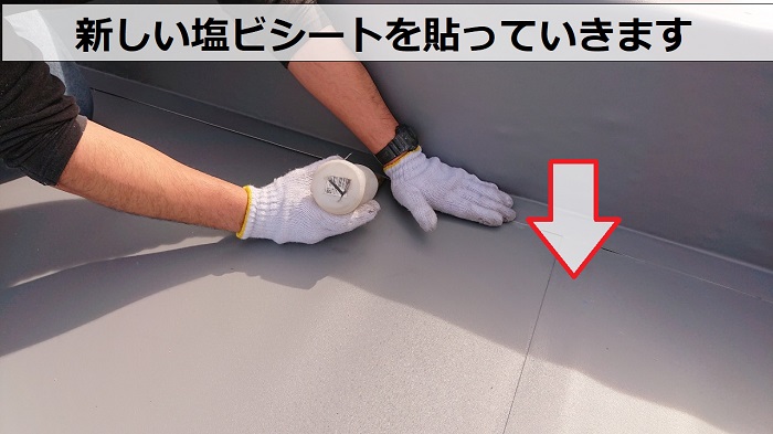 店舗の陸屋根シート防水リフォームで塩ビシートを貼っている様子