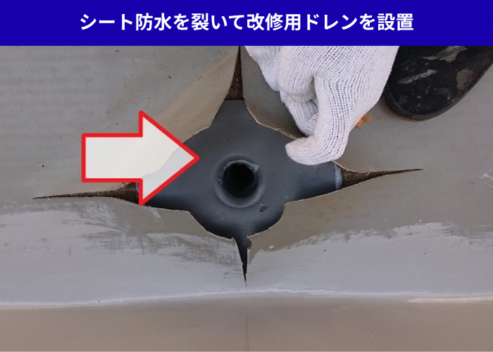 加西市　雨漏りしているシート防水を裂いて改修用ドレンを設置している様子