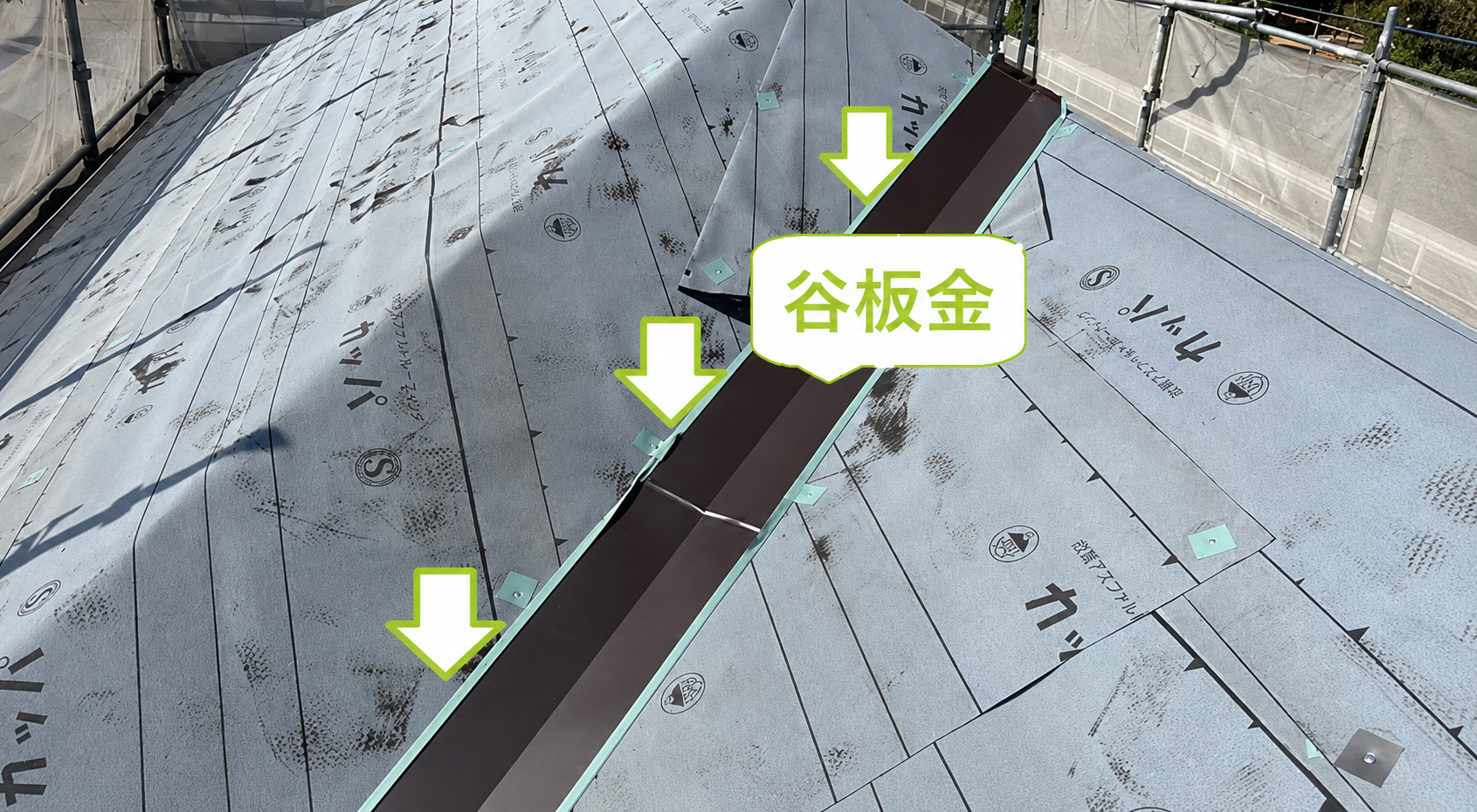 尼崎市の屋根改修工事で谷板金を取り付けている様子
