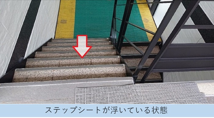 4階建てハイツの共用階段に貼られたステップシートが浮いている様子