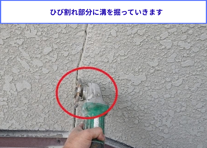 モルタル壁のひび割れ部分に溝を掘っている様子