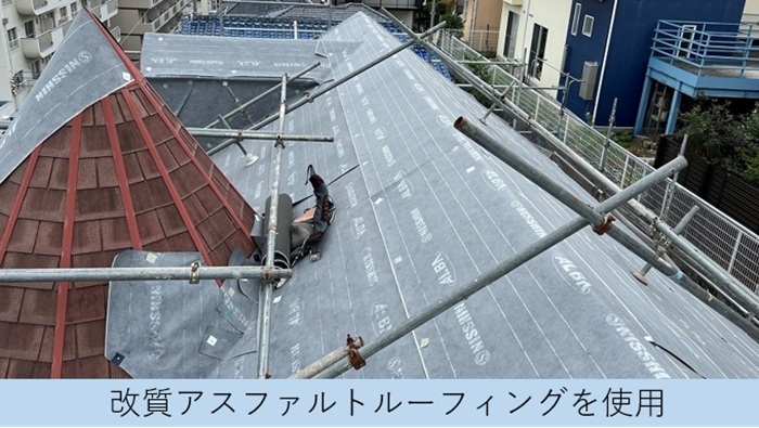 スレート屋根の上から防水シートを貼っている様子