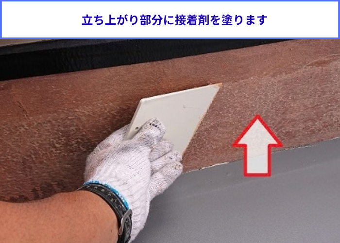 マンションのエントランス上で塩ビシート防水機械固定工法で立ち上がり部分に接着剤塗布