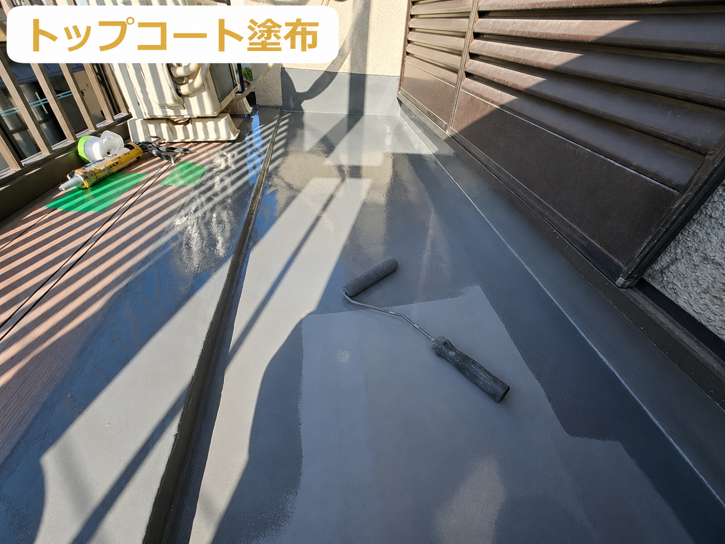 川西市で面積６㎡のクラックが発生したバルコニーへのウレタン防水密着工法を行う現場でトップコート塗布