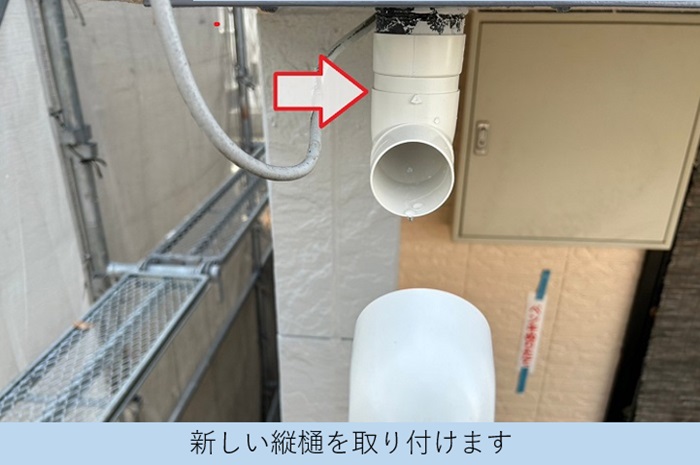 ３階建てハイツで新しい竪樋を取り付けている様子