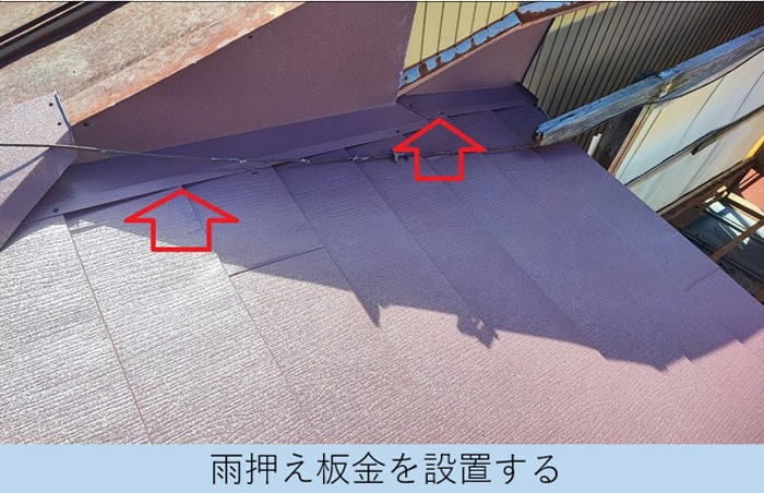 スレート屋根の壁際に雨押え板金を取りつけている様子