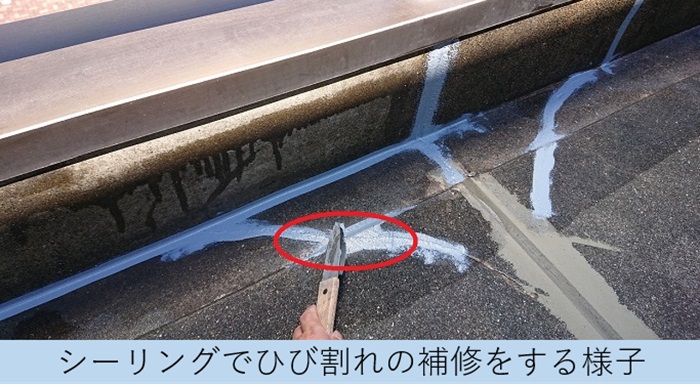 共用廊下のひび割れ個所をシーリングで補修している様子