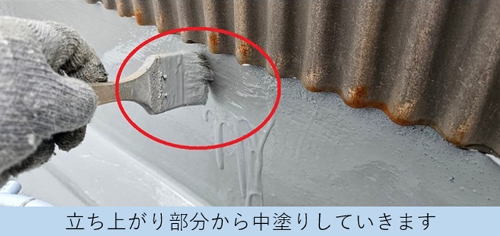 2階建てアパートのバルコニーの立ち上がり部分からウレタン防水を中塗りしている様子