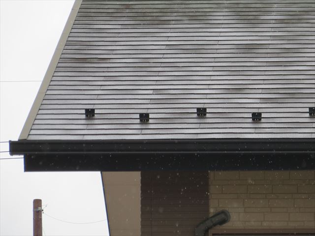 雪止め金具は軒先に設置されて、棟から滑り落ちてくる雪を堰き止めて軒下を守る