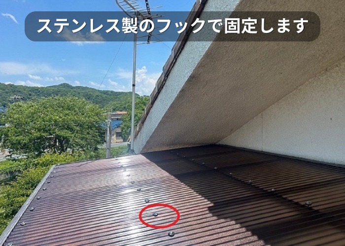 市川町　2階ベランダ屋根の貼り替えで波板をステンレス製のフックで固定している様子
