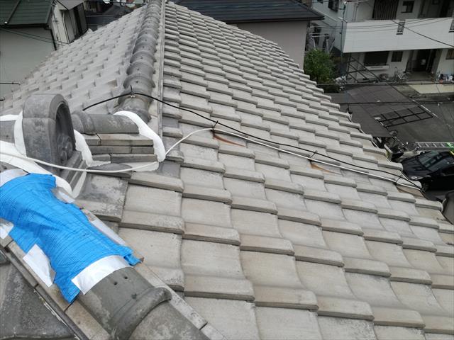 高槻市で台風の二次被害と言える瓦破損屋根を調査した。本格修理までに雨漏りしないよう、隅棟の紐丸（冠瓦）が欠損した箇所をブルーシートで覆う対策を講じた。