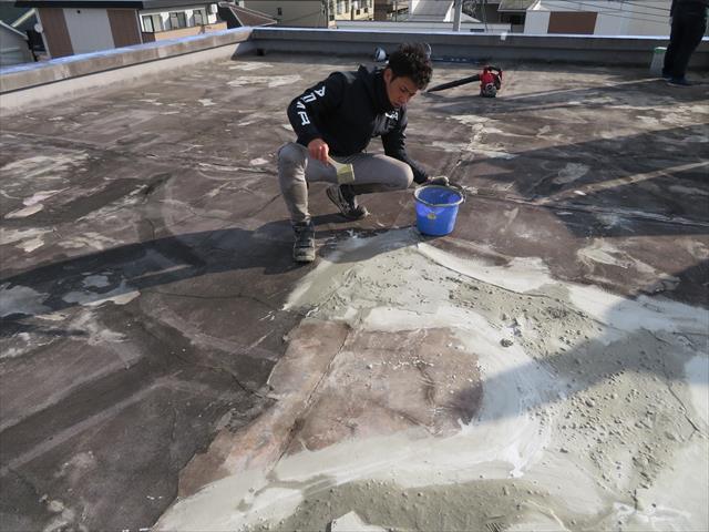 塩ビシート防水工事前に陸屋根表面のシンダーコンクリート土間をカチオン性モルタルでしごき表面を均す