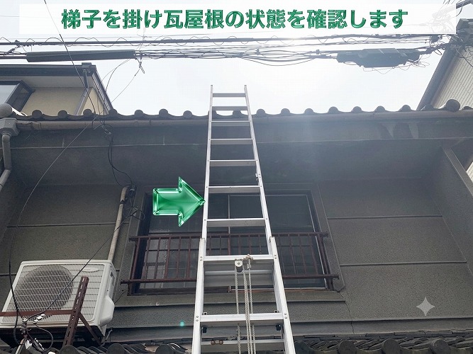 瓦屋根修理後の様子を確認するために梯子を掛けている様子