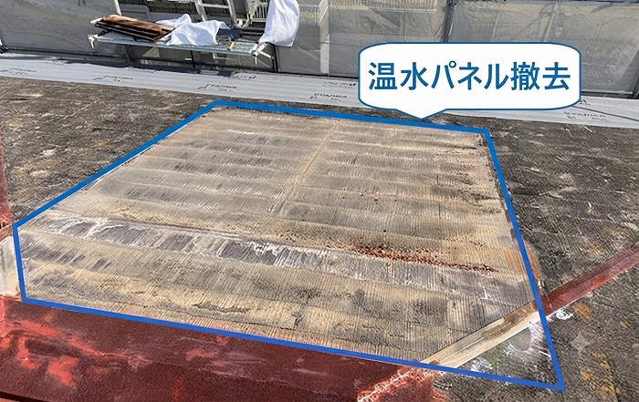 宝塚市の重ね葺き工事でカラーベスト屋根に設置された温水パネルを撤去している様子