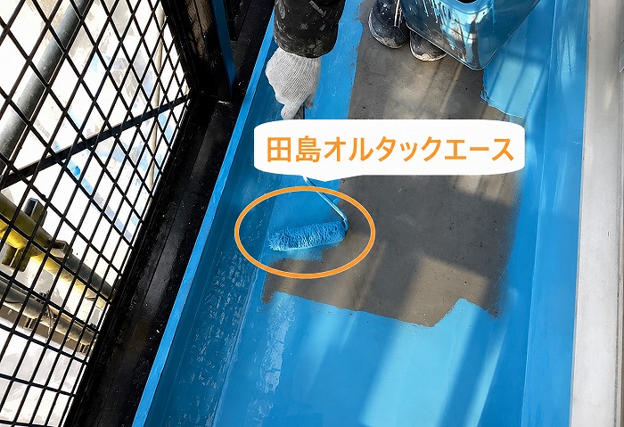 集合住宅のベランダ防水工事の中塗りで田島オルタックエースを使用している様子