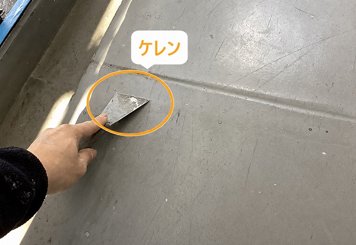 集合住宅のベランダ防水工事でケレンしている様子