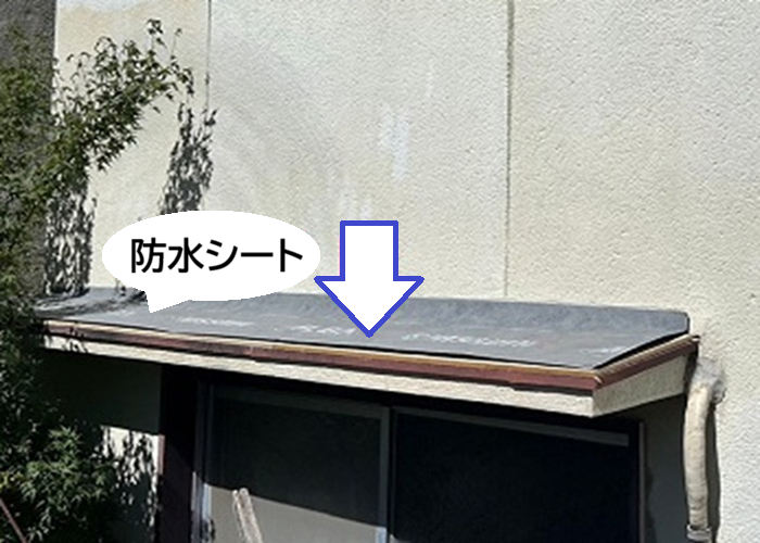 小庇の補修で防水シートを貼っている様子
