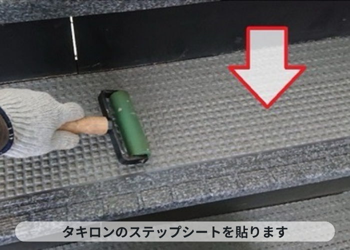西宮市　4階建てハイツで共用階段にステップシートを貼っている様子