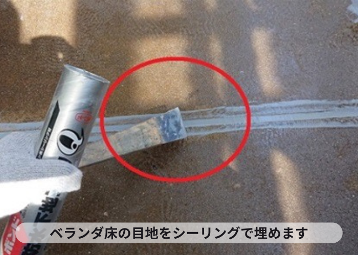 西宮市　ベランダ床に設けられている目地をシーリングで埋めている様子