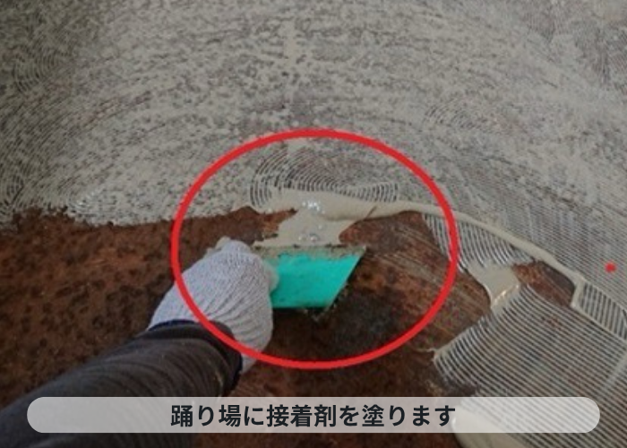 西宮市　共用階段の踊り場に接着剤を塗っている様子