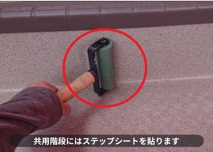 尼崎市　共用階段にステップシートを貼っている様子