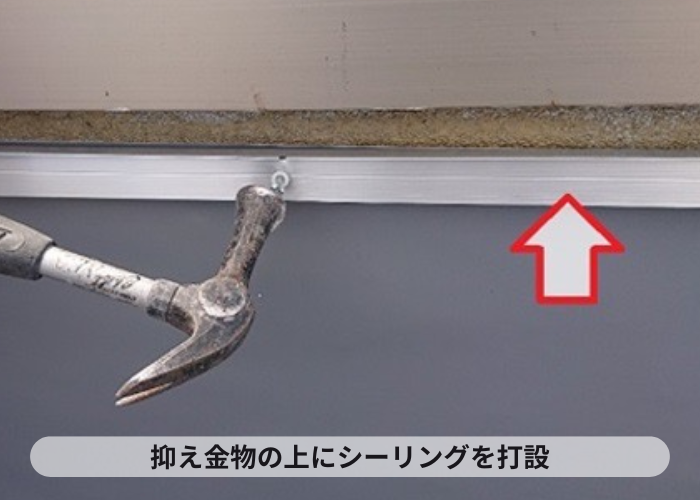 尼崎市　塩ビシート機械固定工法で抑え金物の上にシーリングをしている様子