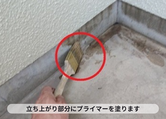 西宮市　ベランダ防水工事で立ち上がり部分からプライマーを塗っている様子