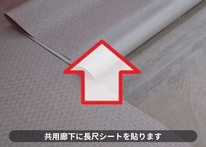 尼崎市　共用廊下に長尺シートを貼っている様子