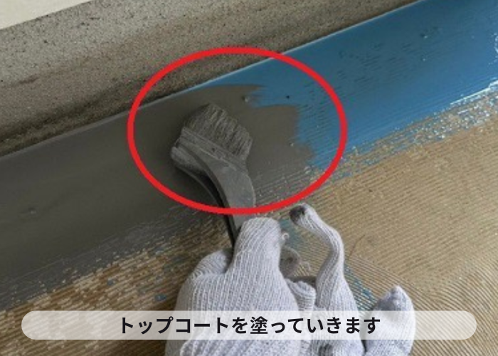 市川町　共用廊下の端部にトップコートを塗っている様子