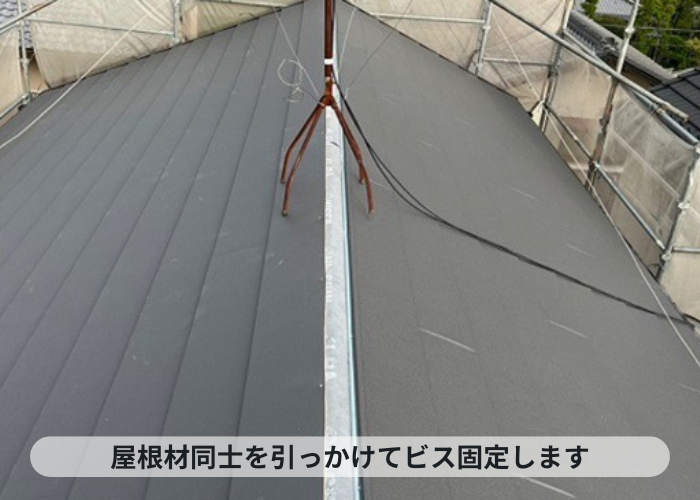 西宮市　屋根葺き替え工事でSGL鋼板屋根材をビス固定している様子