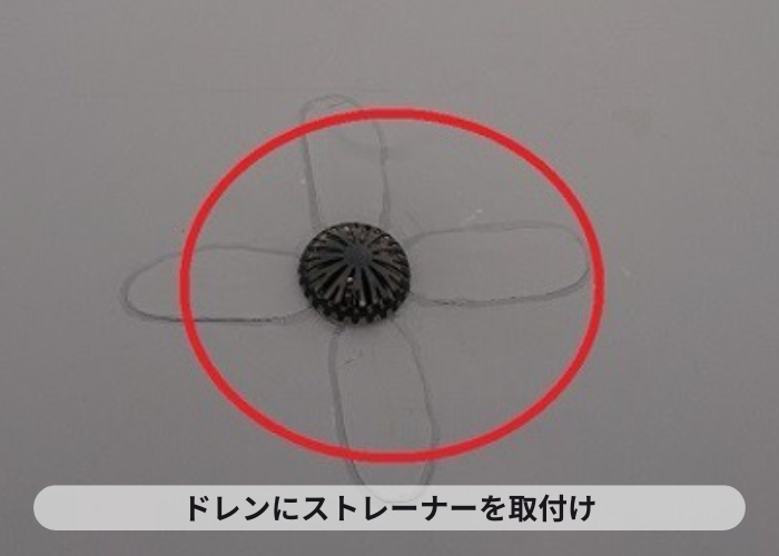 尼崎市　屋上のドレンにストレーナーを取り付けている様子