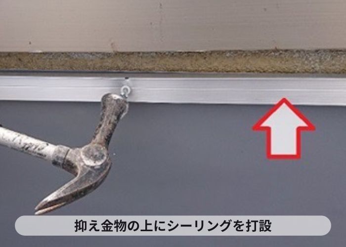 尼崎市　塩ビシート機械固定工法で抑え金物の上にシーリングをしている様子