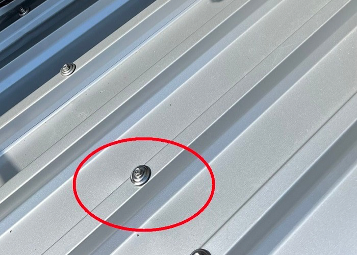 ガルバリウム鋼板屋根をステンレスのビスで固定している様子