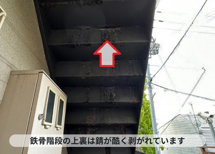 鉄骨階段の上裏が錆びて剥がれている様子