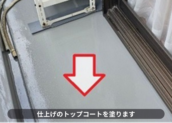 芦屋市　ベランダ防水工事で仕上げのトップコートを塗っている様子