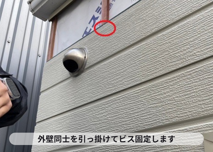三木市で剥がれた外壁サイディングに金属サイディングをカバーする現場で外壁同士を引っ掛けてビス固定