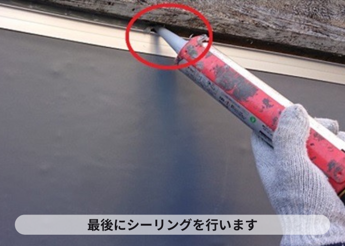 尼崎市　陸屋根防水工事で仕上げのシーリングを行ている様子
