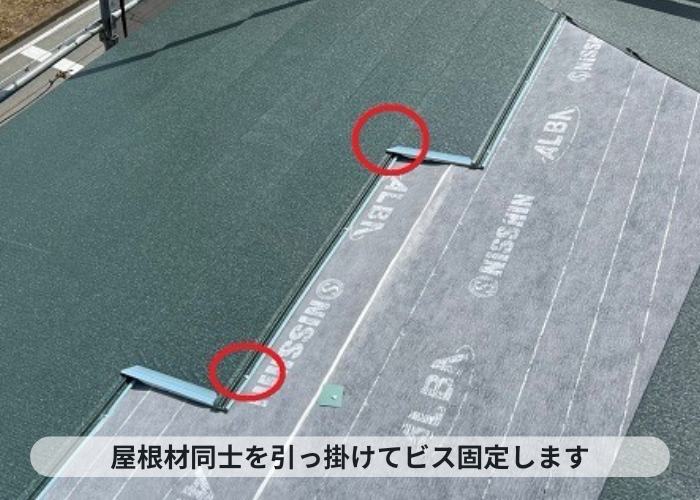 神戸市中央区　3階建てスレート屋根への重ね葺き工事で屋根材をビス止めしている様子