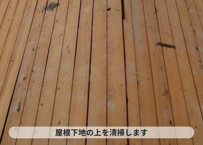 西宮市　屋根葺き替え工事で下地の上を清掃している様子