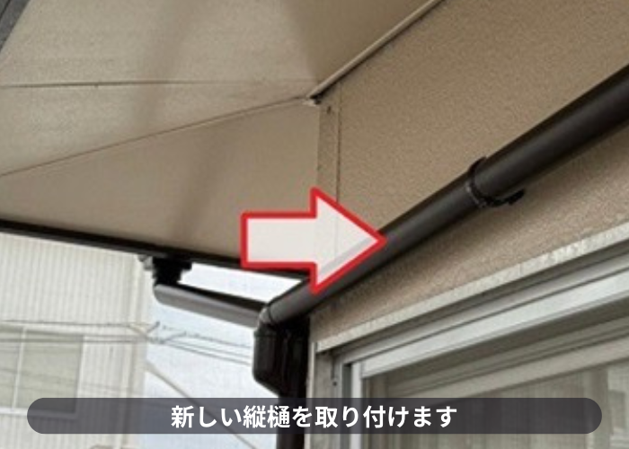 猪名川町　雨樋工事で新しい竪樋を取り付けている様子