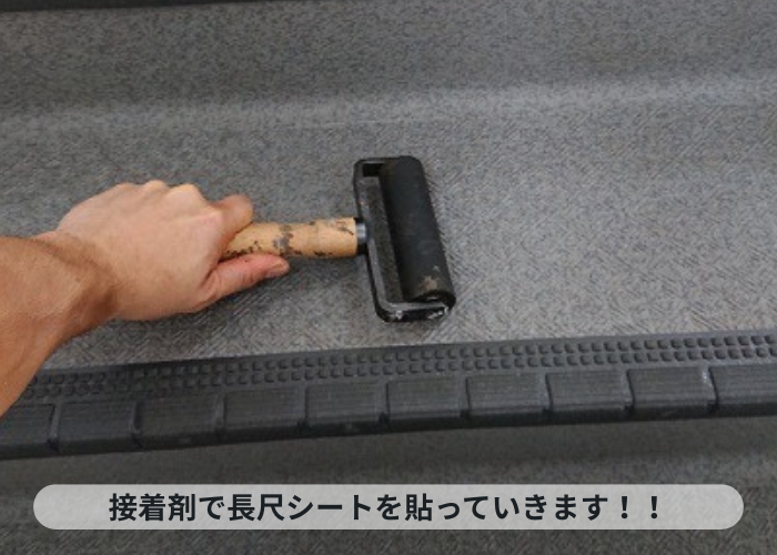 神戸市中央区　接着剤で共用階段に長尺シートを貼っている様子