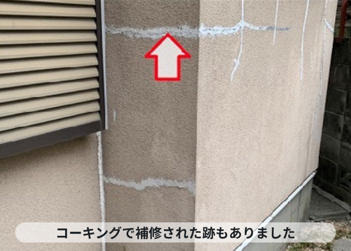 尼崎市　モルタル壁のひび割れにコーキング補修している様子