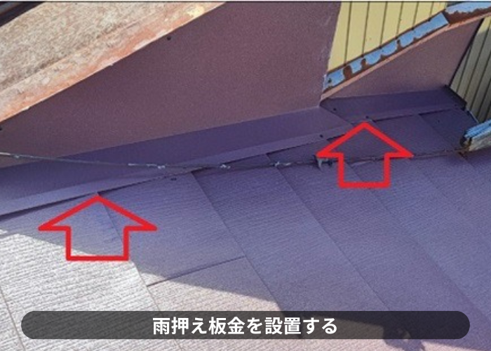 西宮市　スレート屋根の壁際に雨押え板金を取りつけている様子