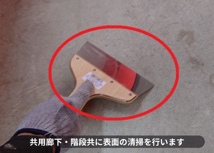 尼崎市　共用廊下・階段の表面をケレンしている様子