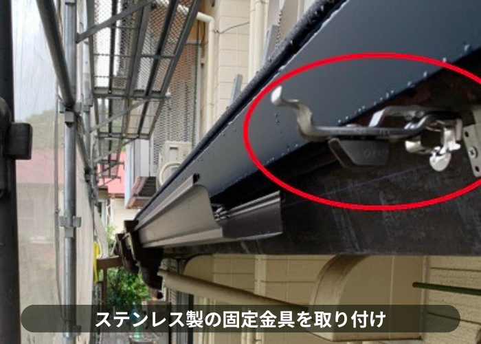 宝塚市　雨樋の部分交換でステンレス製の固定金具を取り付けている様子