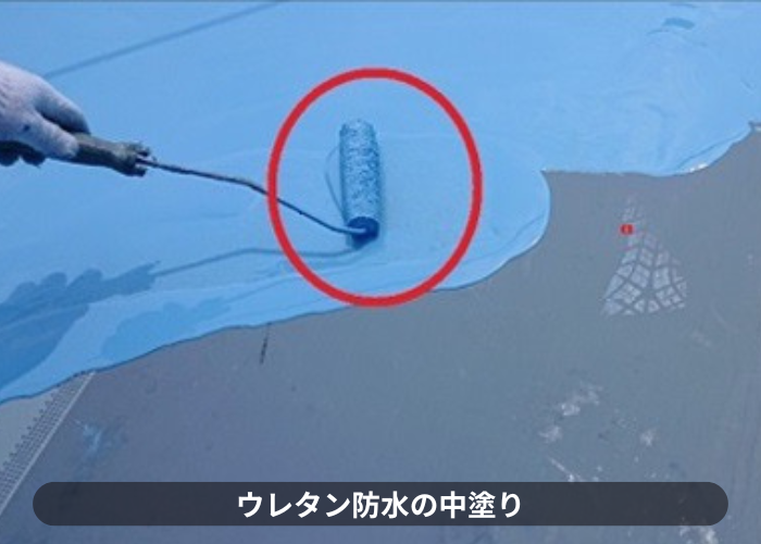 伊丹市　マンションの屋上防水工事でウレタン防水材を中塗りしている様子