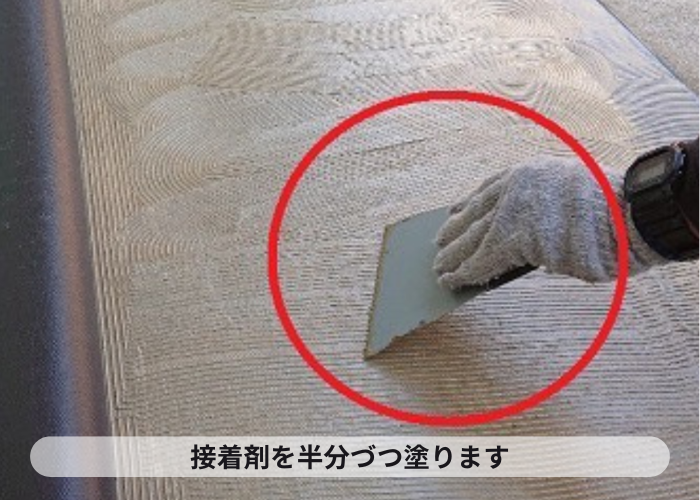 市川町　ハイツの共用廊下リフォームで長尺シートの接着剤を塗っている様子