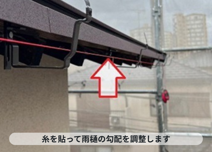 尼崎市　糸を貼って雨樋の勾配を調整している様子